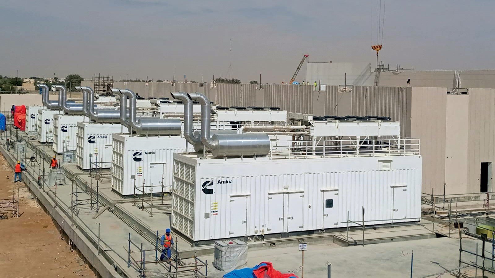 Row of containerized Cummins generators staged at jobsite